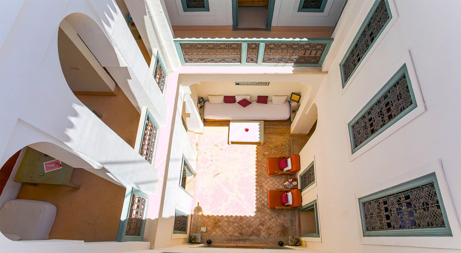 Dar Aicha : cour avec décor marocain traditionnel, carreaux colorés et coin salon confortable dans la Médina de Marrakech