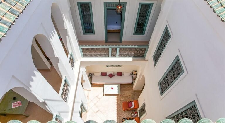 Dar Aicha courtyard with traditional Moroccan decor, colorful tiles, and a cozy seating area in Marrakech Medina