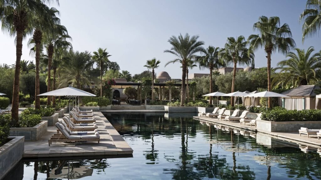 Piscine principale du Four Seasons Resort Marrakech entourée de palmiers et de cabanes