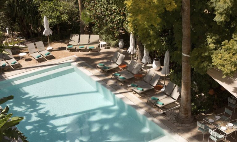 Peaceful swimming pool surrounded by tropical plants at Les Jardins de la Médina Marrakech