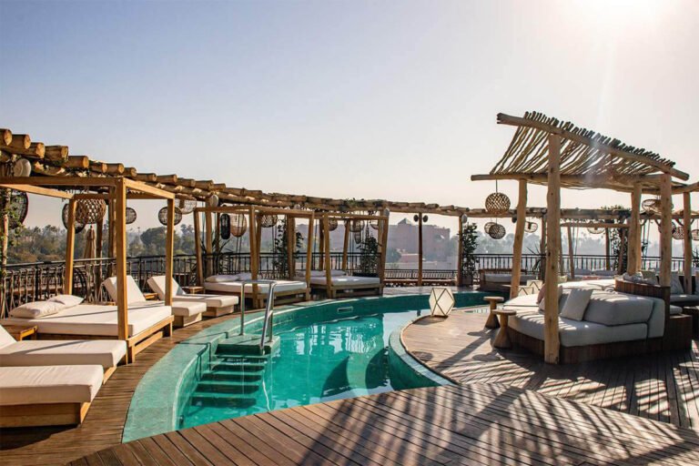 Rooftop pool at Nobu Hotel Marrakech with lounge area and views over Marrakech and the Atlas Mountains