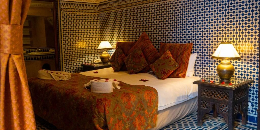 Luxury suite at Riad Palais Sebban featuring ornate decor, carved wood details, and rich Moroccan styling