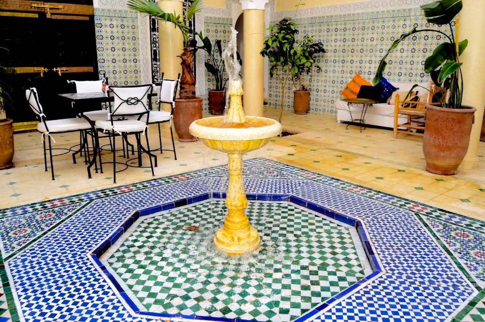 Riad Dar Hamid : cour avec architecture marocaine traditionnelle, végétation et coin salon dans la Médina de Marrakech