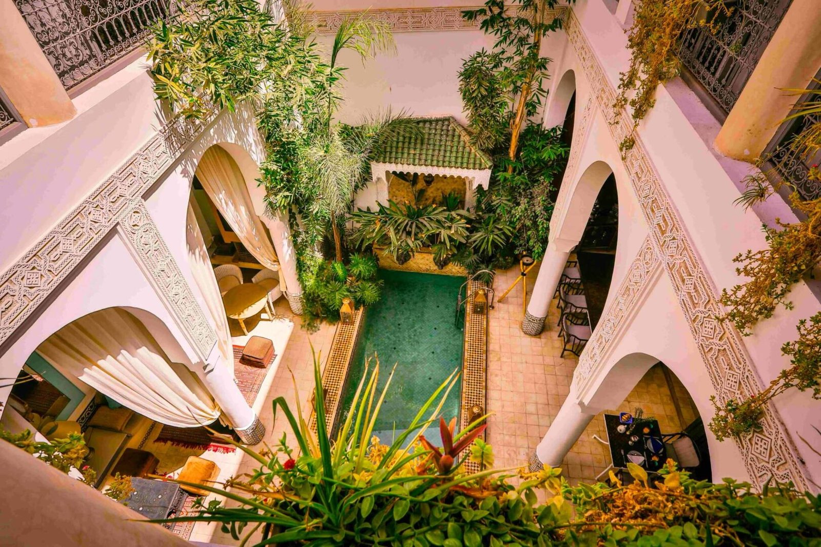 Riad Dar Saad : cour avec carreaux marocains traditionnels, végétation luxuriante et coin salon paisible dans la Médina de Marrakech