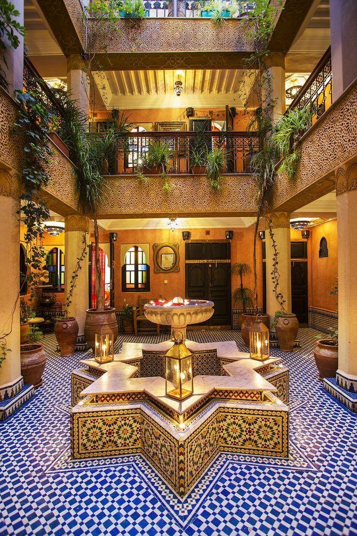Patio traditionnel avec une table centrale au Riad Jnane Mogador à Marrakech.