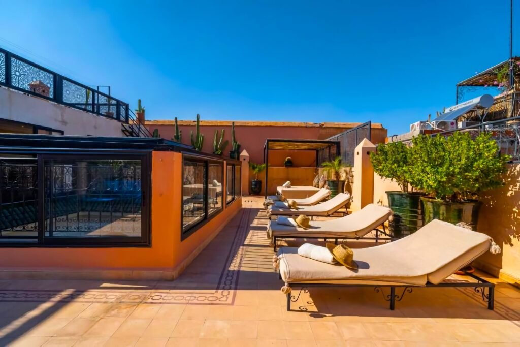 Rooftop terrace at Riad Beldi with lounge seating and views over Marrakech Medina
