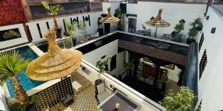Rooftop terrace at Riad Dar Najat with seating, plants, and views over the Marrakech Medina