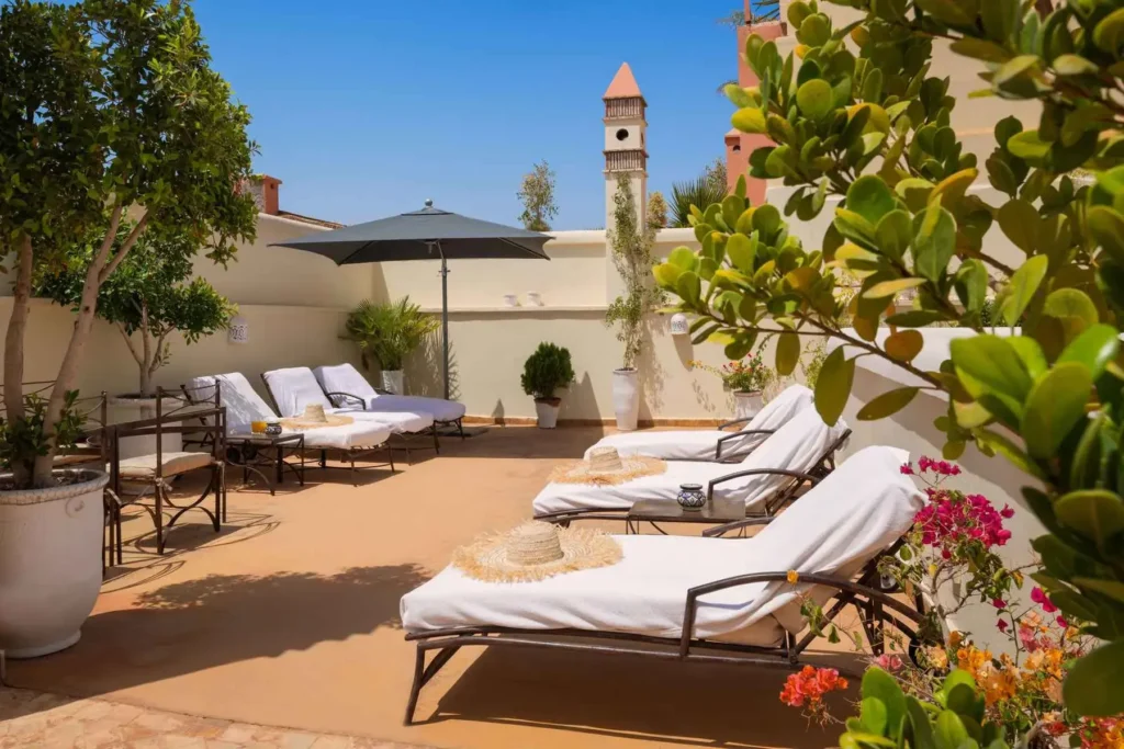Salon rooftop du Riad Joya avec atmosphère calme et vue panoramique sur Marrakech