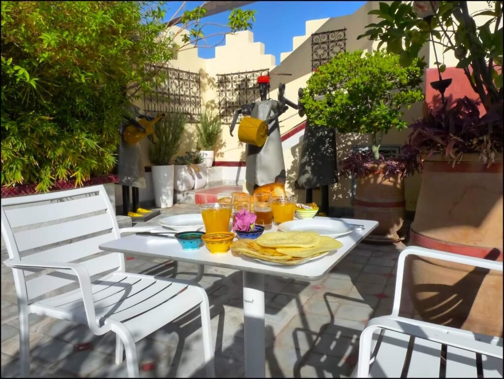 Dining area at Riad Noos Noos with creative Moroccan breakfast setting and warm social ambiance