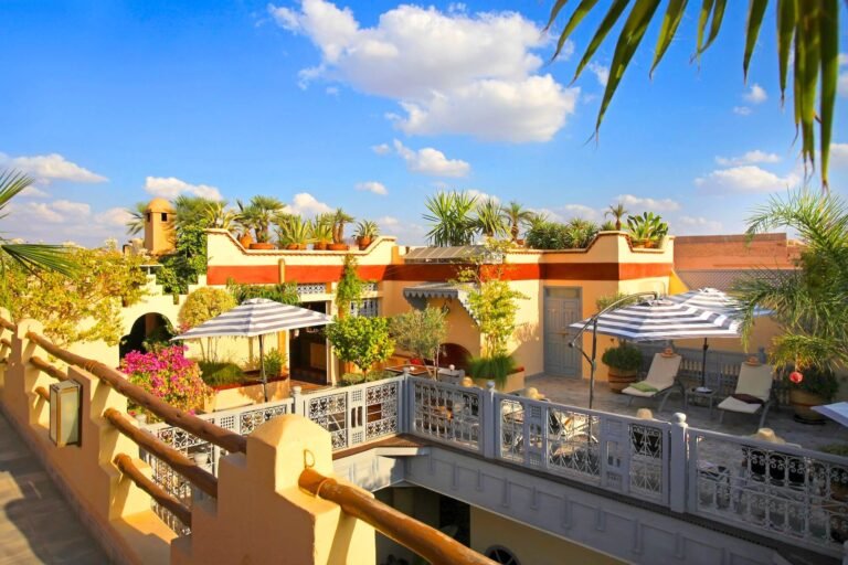 Rooftop terrace at Riad Noos Noos with colorful seating and views over Marrakech Medina