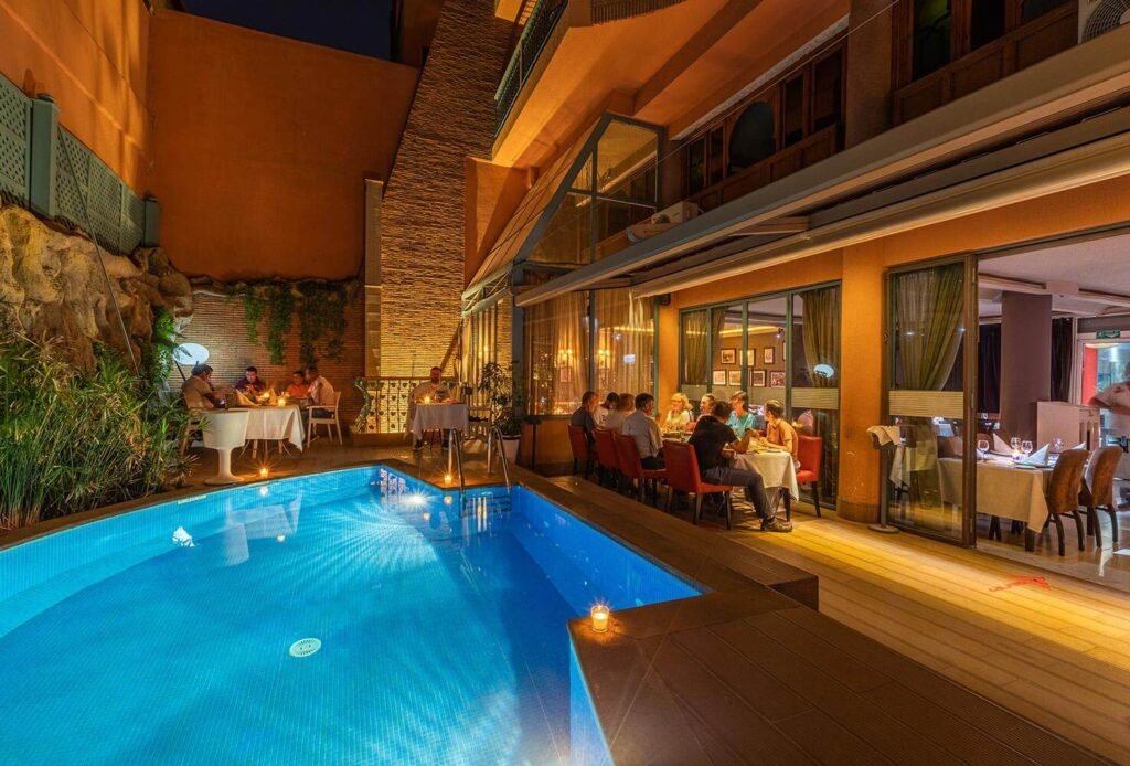 Espace de restauration au bord de la piscine du Bistro La Saveur à l’hôtel Le Caspien à Marrakech.