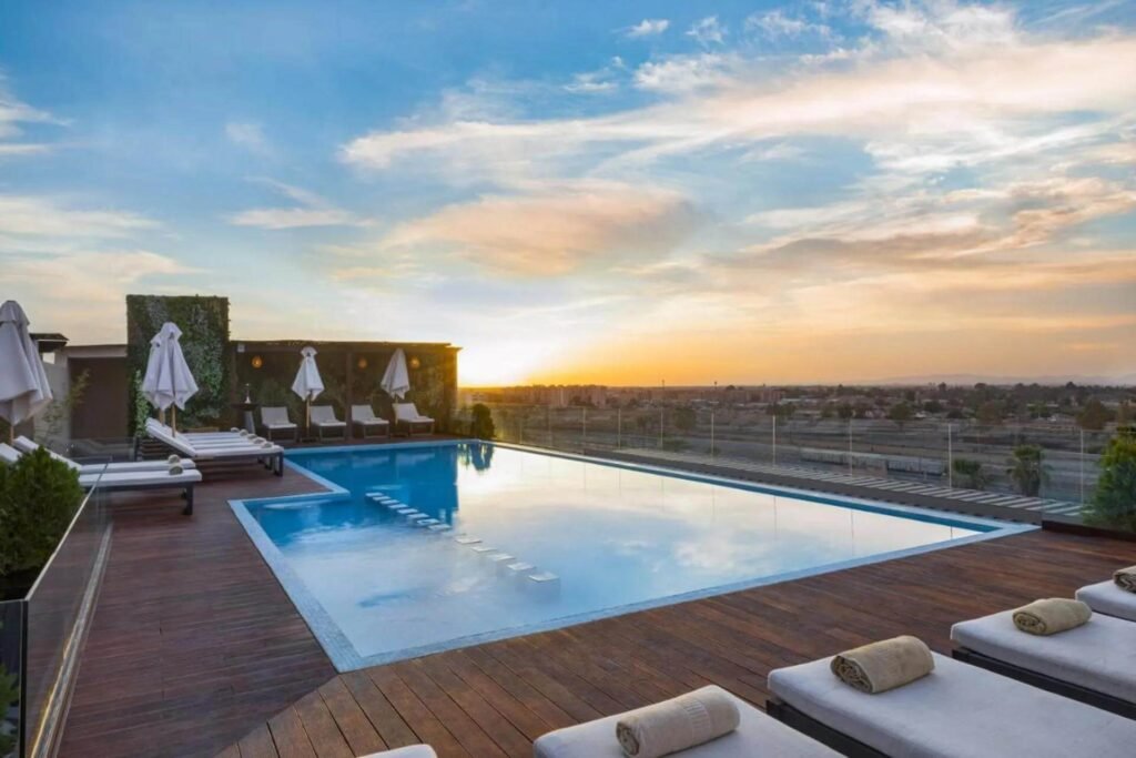 Piscine sur le toit avec des chaises longues et une vue sur la ville au Longue Vie Hotels à Marrakech.