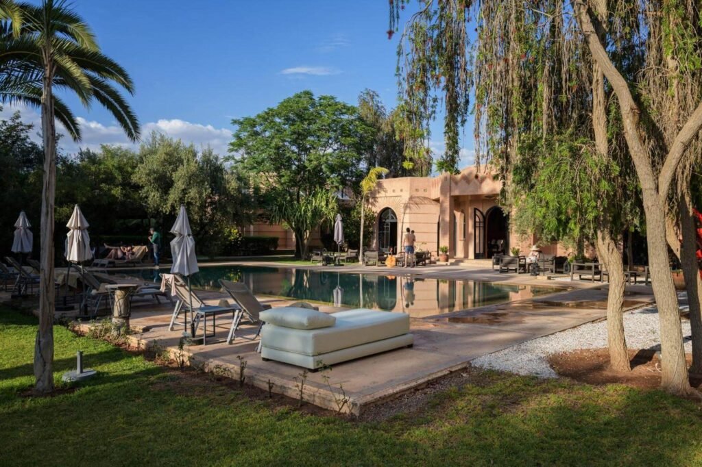 Piscine extérieure et jardin verdoyant de la Villa Al Assala Palmeraie à Marrakech.